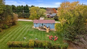 Deck, hot tub, furniture, charcoal grill, fire pit, and games highlight our large back yard.