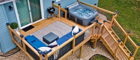 Deck, hot tub, furniture, charcoal grill, fire pit, and games highlight our large back yard.