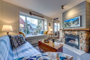 The living room, with shiplap and a Samsung Frame TV above the fireplace, overlooking the stroll below.