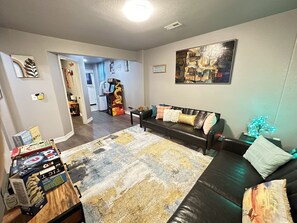 Our living room is all about relaxation, with plush couches, a TV for bonding, and an arcade for hours of gaming excitement!