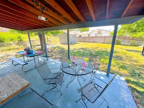 Your private backyard escape with cozy seating, a dining table, and a projector for ultimate relaxation!