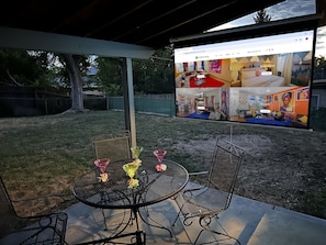Your private backyard escape with cozy seating, a dining table, and a projector for ultimate relaxation!