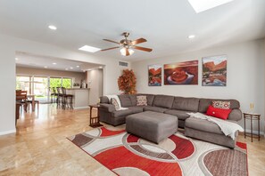 Bright open-floor concept living room featuring comfortable sectional and smart TV.