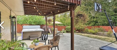 Fully fenced backyard, featuring multiple entreatment areas, hot tub, fire pit