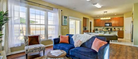 Cozy relaxation awaits in this living room, featuring a plush couch perfect for unwinding. The large window frames tranquil lake views, inviting serenity into the space.