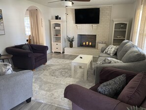 Comfy living room with 55" smart tv, remote candles in fireplace