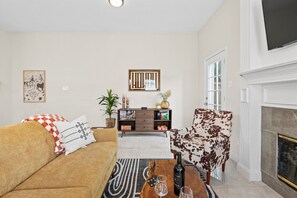 Living room with couch, board games, fireplace, and TV