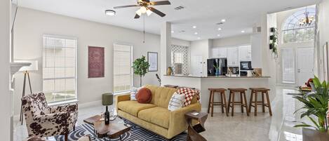 Open concept area of living room and kitchen with bar seating