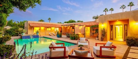 Relaxing seating area near the pool, offering a comfortable place to bask in the sun or enjoy some shade while appreciating the poolside atmosphere.