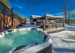 Enjoy the large deck with outdoor kitchen, lounge area, pool table, and hot tub