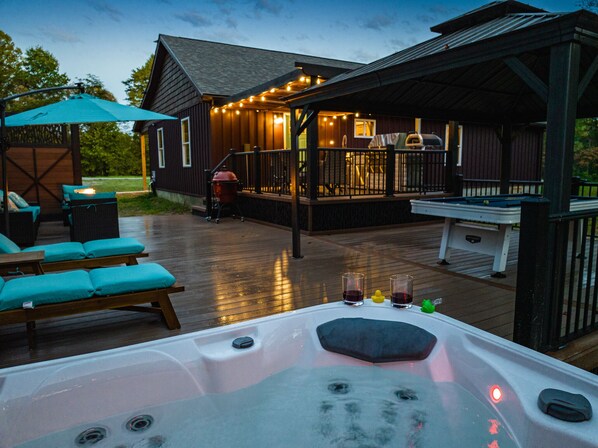 Enjoy the large deck with outdoor kitchen, lounge area, pool table, and hot tub