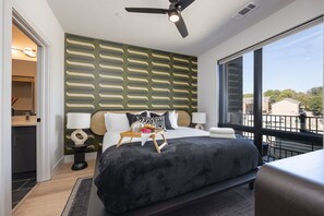 Primary Bedroom with King bed, smart TV, floor to ceiling windows, and en-suite bathroom.