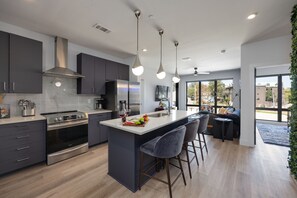 Fully equipped kitchen stocked with your basic cooking essentials. Includes stainless steel appliances, small kitchen island, coffee machine, and toaster.