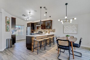 Huge kitchen with dining table and stainless steel appliances