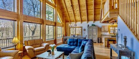 Open concept Living room with bamboo flooring, wooden ceiling, comfortable couches and arm chairs