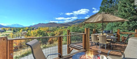 Deck with fire pit and dining area with views