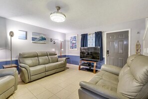 Open living/kitchen/dining with smart TV and half bath access.
