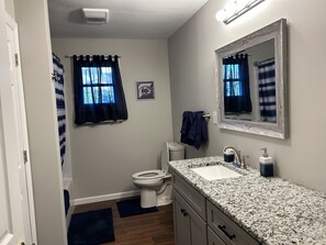 Full bathroom with towels, shampoo, conditioner, body wash, toilet paper, etc