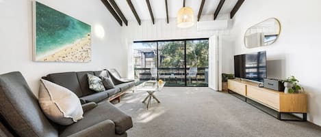 The open plan living and dining area flows to a sunny balcony filling the space with an abundance of natural light and warmth.
