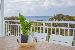 The upstairs balcony overlooks stunning views of the ocean and lush, green surrounds.
