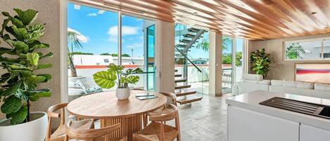  The light-filled dining area includes a six-seater table to share meals together, with views overlooking the balcony. 
