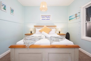 The lovely main bedroom features a queen-sized bed, with side tables and reading lights.