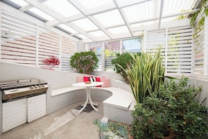The undercover patio area has a built-in curved bench, offering space to enjoy a meal whipped up on the barbecue.