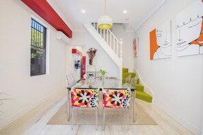 The quirky dining room offers an eight-seater glass table under a funky pendant light.