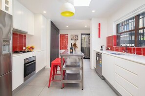 The kitchen comes fully equipped with everything you'll need to cook meals at home, including an industrial-style bench, dishwasher and a large fridge with a water filter.