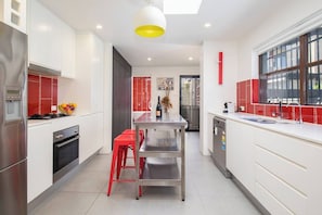 The kitchen comes fully equipped with everything you'll need to cook meals at home, including an industrial-style bench, dishwasher and a large fridge with a water filter.