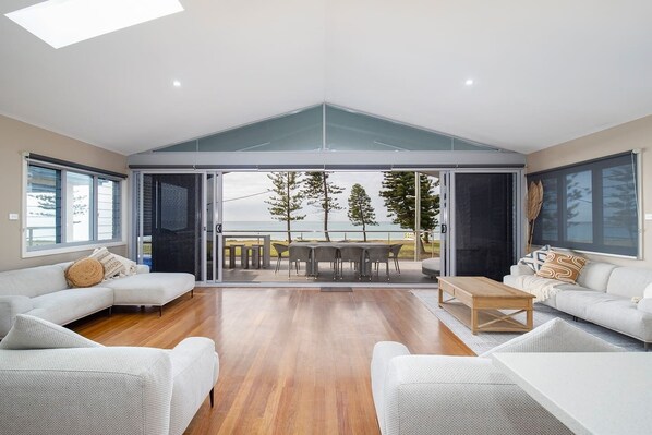 The open plan living space upstairs flows straight to the balcony, capturing natural light and sea breezes.
