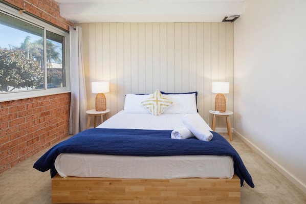 The main bedroom is thoughtfully styled with coastal accents to create a warm and welcoming retreat.