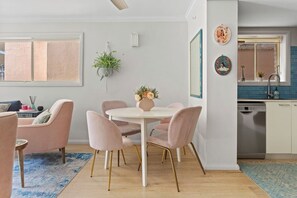The dining area is charming and elegant with a round table that seats four on soft pink velvety chairs with gold accented legs. 
