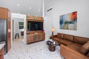 Living room with leather sofa, built in shelves and cupboards, flat screen tv