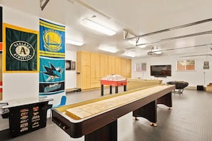 Game room with 75" TV, Shuffle Board Table, Foosball, Dart Board and Arcades.