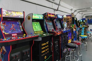 Game room with 75" TV, Shuffle Board Table, Foosball, Dart Board and Arcades.