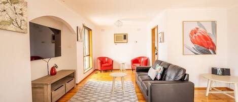 Upon entry, you’ll be greeted by a sitting room to the right with two red leather chairs.