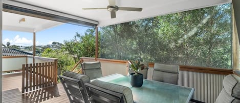 The covered deck offers ample space to dine alfresco under the gentle breeze of the ceiling fan.