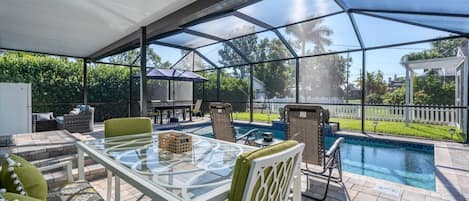 Spacious outdoor area with dining table overlooking the pool
