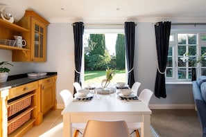 Although cosy, the cottage is light and airy, with french doors that open up to a pretty garden.