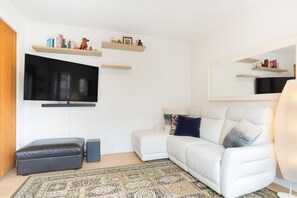 The living room opens to a quaint balcony, allowing an abundance of natural light and fresh breezes to stream through.

