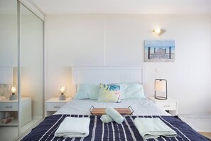 The bright and airy bedroom and living area includes a queen-size bed and a sofa.