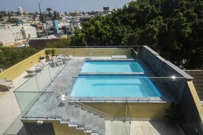 The sun-soaked communal rooftop pool is perfect for enjoying a dip or relaxing on the outdoor furniture.