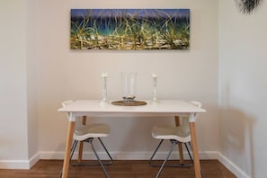 The dining area features a two-person dining table for those wanting to enjoy a romantic meal at home or use as a work desk.