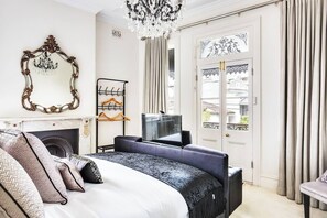 A primary bedroom features a comfortable king bed, a beautiful fireplace and double doors that open out onto the balcony