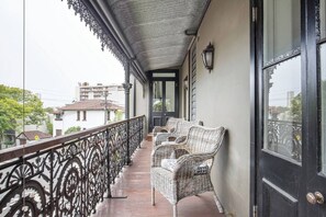 A large, second story balcony runs along the length of the house and provides a space to look out onto the quaint, leafy street
