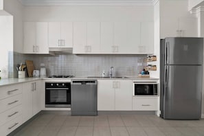 A modern kitchen comes fully equipped for guests to whip up a meal at home, with sleek appliances and utensils.