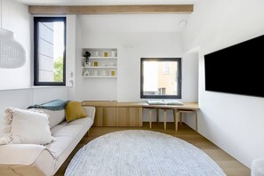 The living area is located on the upper floor with a comfortable sofa and TV for cosy nights at home.
