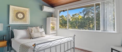 The first bedroom has unique timber ceilings with thoughtful furnishings creating a haven to start and end your day.