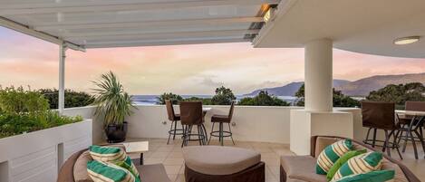 Relax on your private balcony, taking in stunning mountain and ocean views—best enjoyed at sunset.